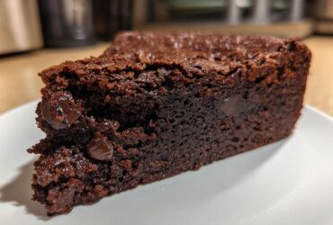 A close-up of a fudgy slice of Black Bean Brownies, showcasing a rich chocolate texture and embedded chocolate chips.