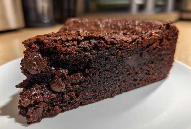 A close-up of a fudgy slice of Black Bean Brownies, showcasing a rich chocolate texture and embedded chocolate chips.