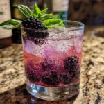 A refreshing Blackberry Basil Gin Smash cocktail with fresh blackberries and basil garnish in a glass with ice.