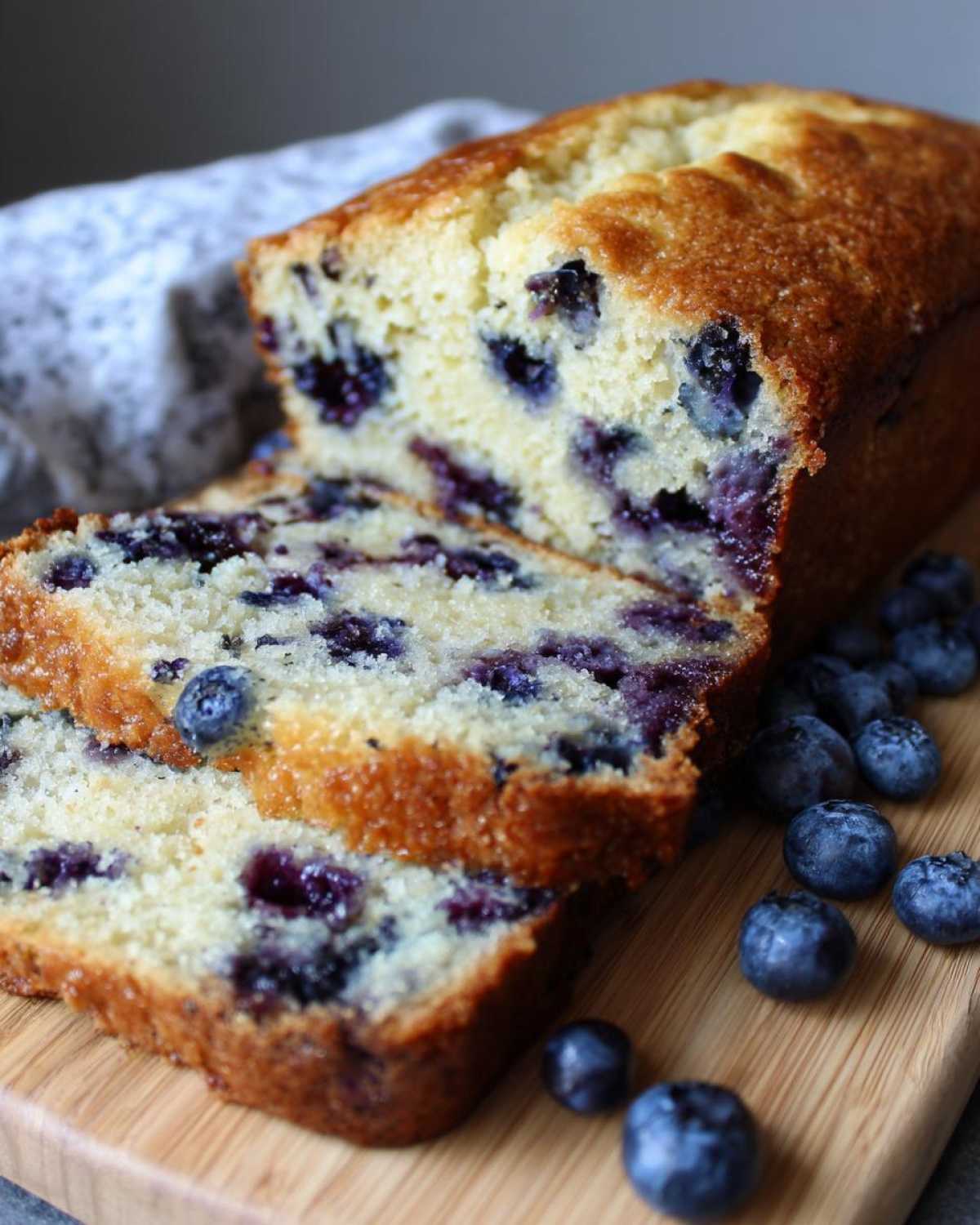 Close-up of moist Blueberry Banana Bread with fresh blueberries baked throughout.