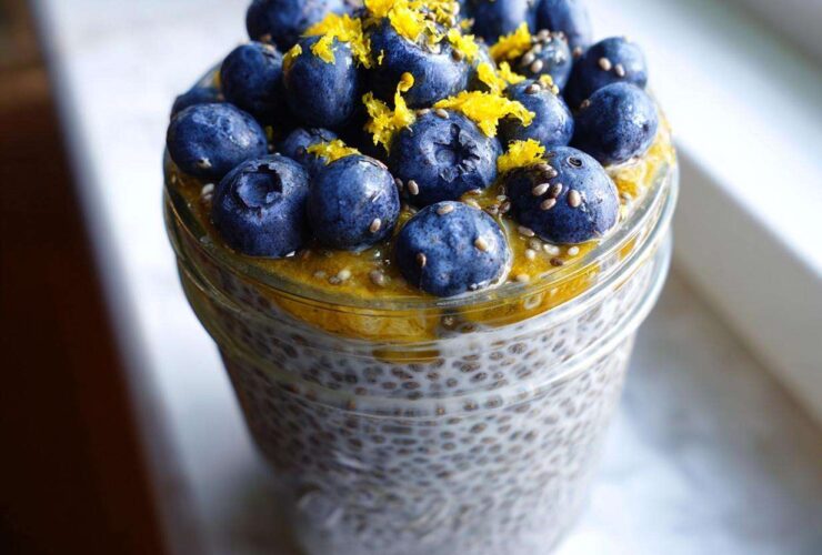 A close-up of Blueberry Lemon Chia Pudding in a jar, topped with fresh blueberries and lemon zest.