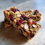 Close-up of two Cherry Almond Energy Bars, packed with oats, dried cherries, raisins, and almonds.