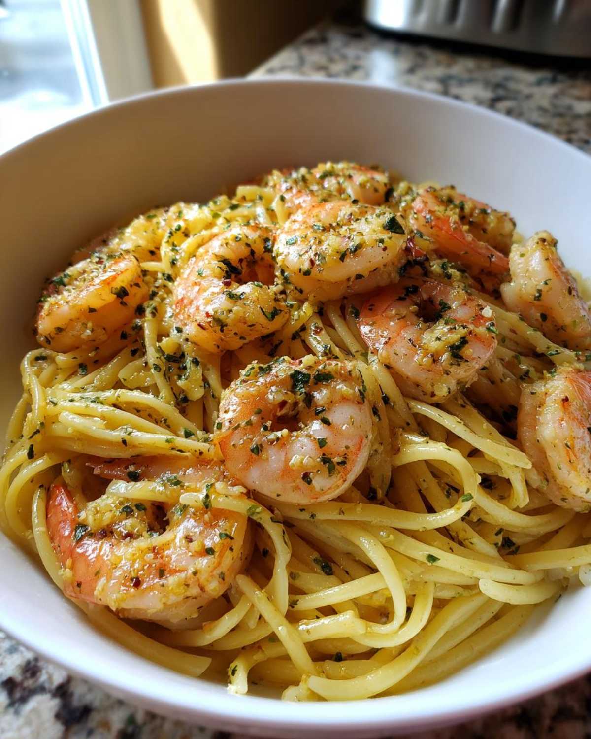 Close-up of Garlic Herb Shrimp Scampi served over linguine pasta in a white bowl.