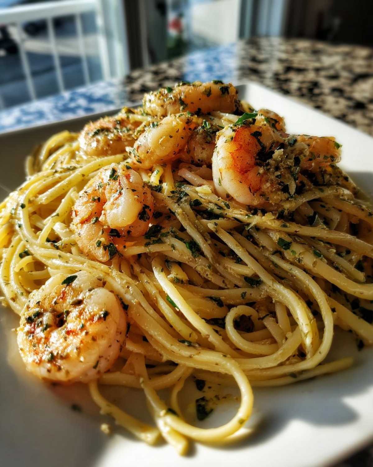 A close-up of Garlic Herb Shrimp Scampi served over linguine pasta, garnished with fresh parsley.