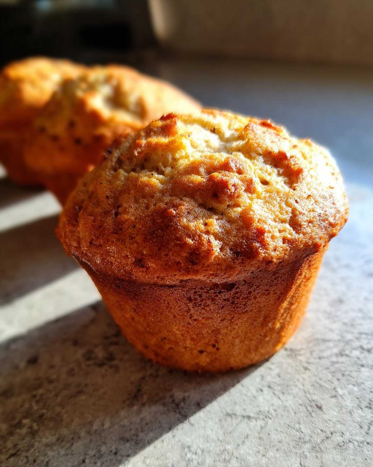 Close-up of a perfectly baked gluten-free banana muffin with a golden-brown crust.