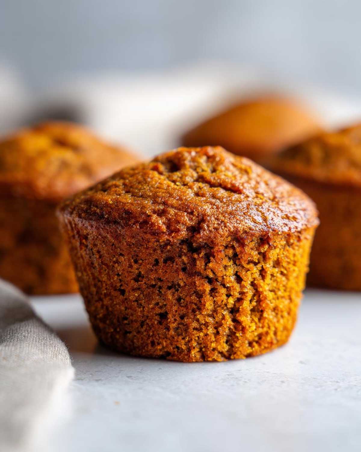 Close-up of a perfectly baked gluten-free pumpkin muffin with a slightly domed top.