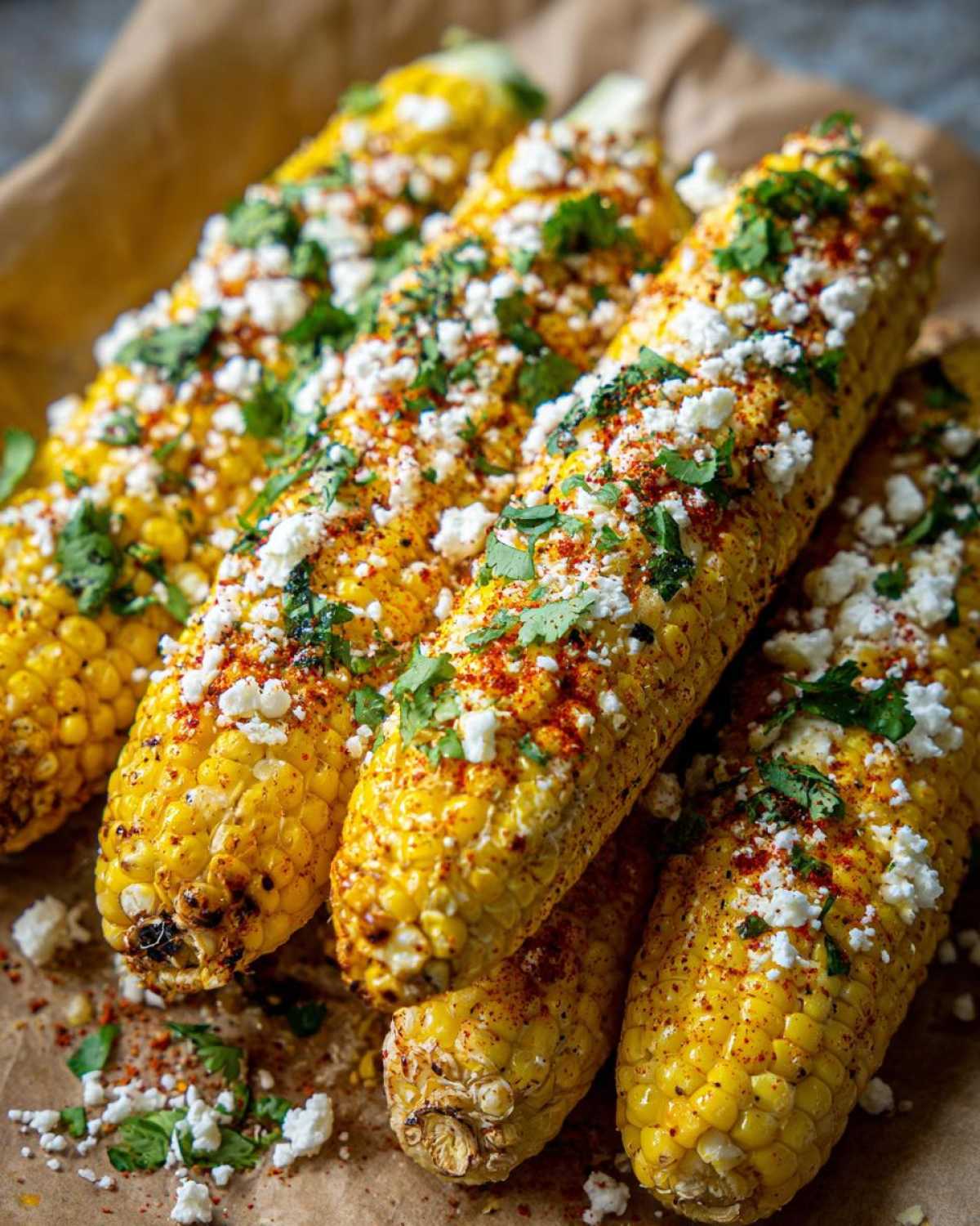 Close-up of Instant Pot Mexican street corn, topped with crumbled cotija cheese, chili powder, and cilantro.