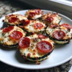 A plate of delicious Keto Zucchini Pizza Bites topped with melted cheese and pepperoni slices.