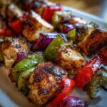 Close-up of grilled Mediterranean Chicken Kabobs with colorful bell peppers and red onion.