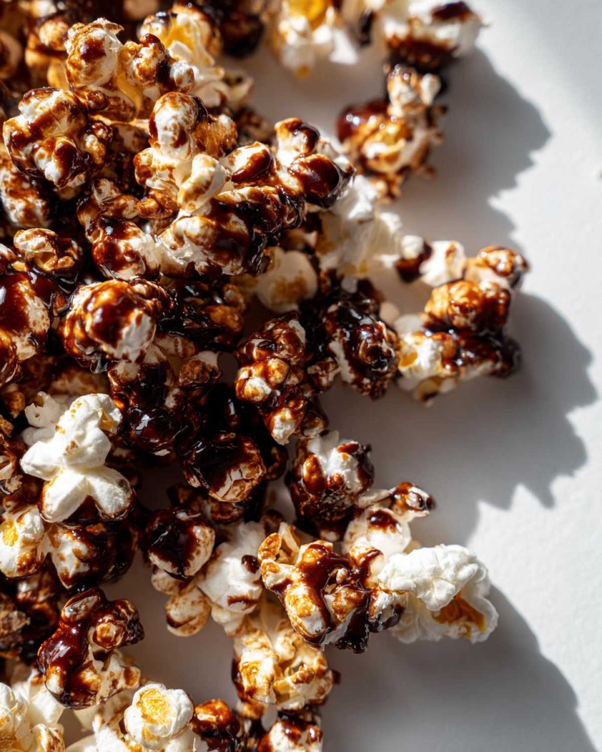 A close-up shot of freshly made Mocha Drizzle Popcorn, showcasing the glossy chocolate drizzle over fluffy popcorn kernels.