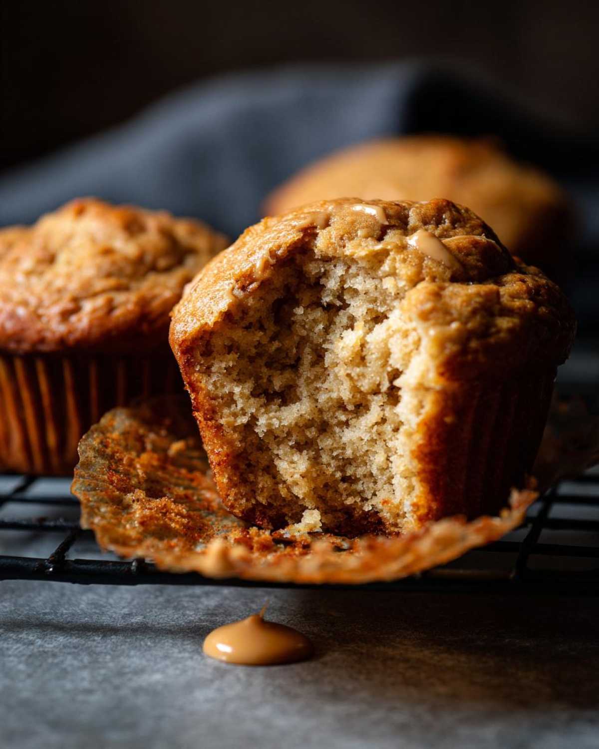 Close-up of a delicious peanut butter protein muffin with a bite taken out, showing its fluffy interior.