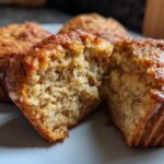 Close-up of a delicious peanut butter protein muffin, split in half to reveal its fluffy interior.