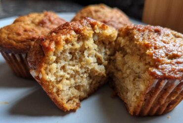 Close-up of a delicious peanut butter protein muffin, split in half to reveal its fluffy interior.