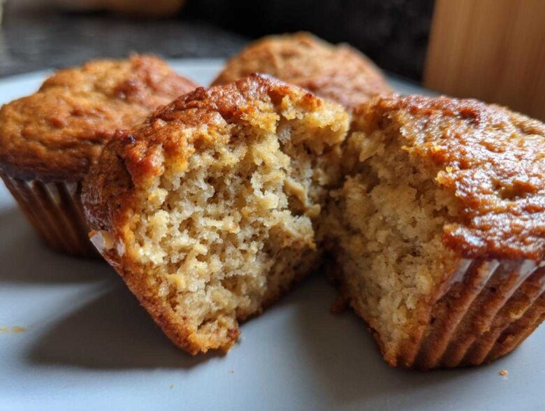 Close-up of a delicious peanut butter protein muffin, split in half to reveal its fluffy interior.