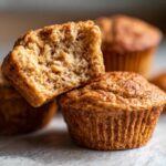 Close-up of a split peanut butter protein muffin, revealing a fluffy interior.