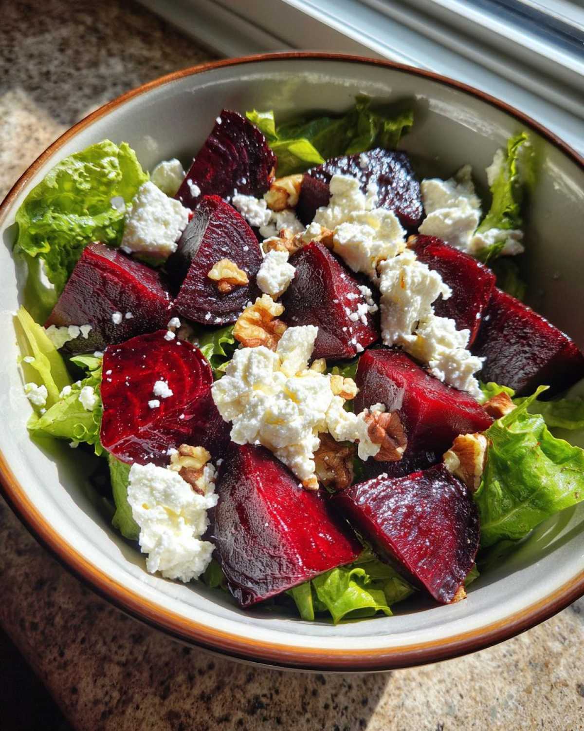 A vibrant Roasted Beet & Goat Cheese Salad featuring bright red beets, crumbled goat cheese, crunchy walnuts, and fresh lettuce.