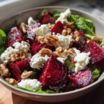 A vibrant Roasted Beet & Goat Cheese Salad featuring chunks of roasted beets, crumbled goat cheese, and toasted walnuts on a bed of greens.