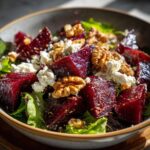 Close-up of a vibrant Roasted Beet & Goat Cheese Salad with fresh greens, crumbled goat cheese, and toasted walnuts.
