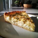 A delicious slice of Rosemary Goat Cheese Tart on a plate, showcasing the creamy filling and flaky crust.