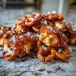 A close-up, mouth-watering view of a pile of Irresistible Salted Caramel Pretzel Bites, glistening with caramel and topped with flaky sea salt.