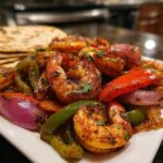 A close-up of delicious Sheet Pan Shrimp Fajitas featuring plump shrimp, colorful bell peppers, and red onions, garnished with fresh parsley.