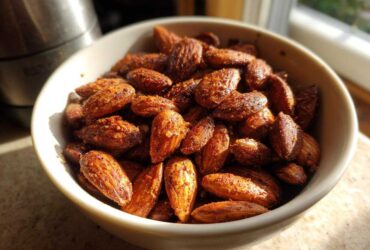 A close-up of a bowl filled with delicious Smoky Paprika Almonds, seasoned and ready to eat.