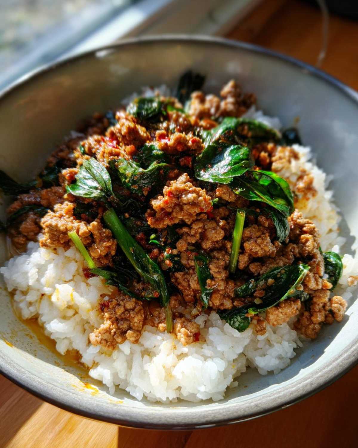 Close-up of a bowl of white rice topped with flavorful Spicy Thai Basil Beef (Pad Kra Pao).