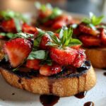 Close-up of Strawberry Balsamic Bruschetta on a plate, featuring toasted bread topped with fresh strawberries, basil, and balsamic glaze.