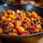 Close-up of a hearty Sweet Potato & Black Bean Hash cooked in a cast iron skillet.