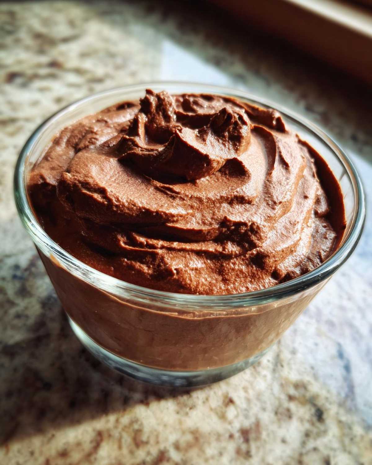 A close-up of a glass bowl filled with rich, creamy Vegan Chocolate Avocado Mousse.