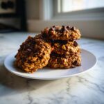 A stack of five hearty, oatmeal-based chocolate chip breakfast cookie piled on a small white plate.