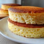 Close-up showing the incredibly airy and fluffy pancakes texture stacked on a white plate.