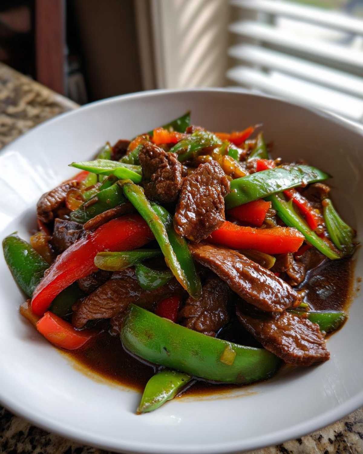 Close-up of tender beef slices and vibrant peppers in a rich sauce, showcasing the amazing 30-Minute pepper steak.