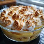 Close-up of amazing banana pudding in a glass dish, topped with perfectly toasted meringue peaks.