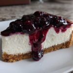A perfect slice of amazing blueberry cheesecake featuring a thick graham cracker crust and rich blueberry topping.