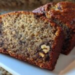 Close-up of a moist slice of the best banana bread, showing walnuts embedded in the crumb.