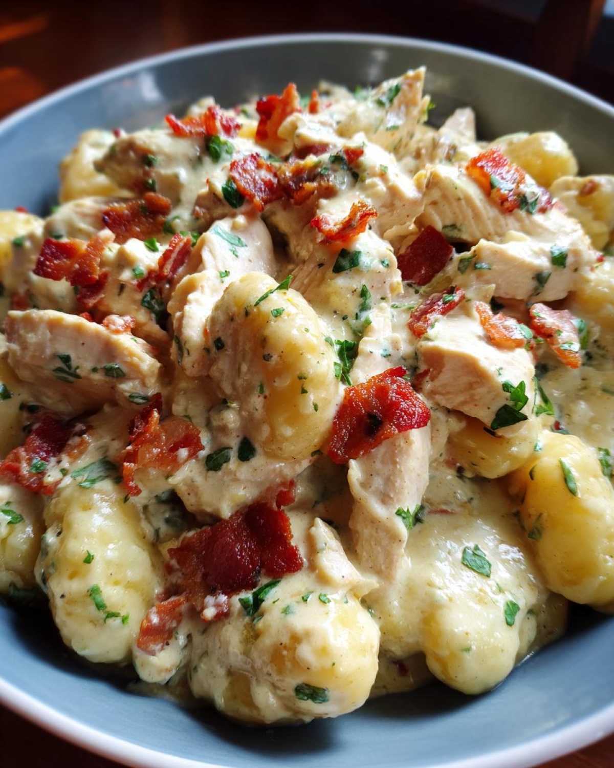 A close-up view of creamy crack chicken gnocchi, featuring tender chicken, soft gnocchi, and crispy bacon pieces.