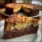 A close-up slice of german chocolate cheesecake showing distinct layers: a dark chocolate base, a creamy filling, and a toasted coconut topping.