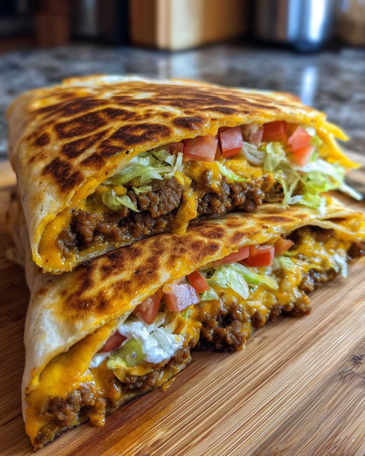 Close-up of a Copycat Taco Bell Crunchwrap Supreme cut in half, showing seasoned beef, cheese, lettuce, and sour cream.