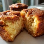 Close-up of a cinnamon sugar french toast muffin broken in half, showing the fluffy interior.