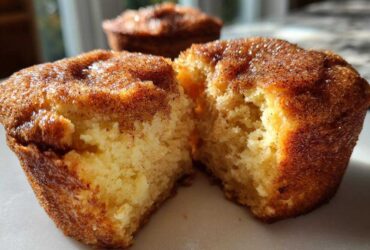Close-up of a cinnamon sugar french toast muffin broken in half, showing the fluffy interior.