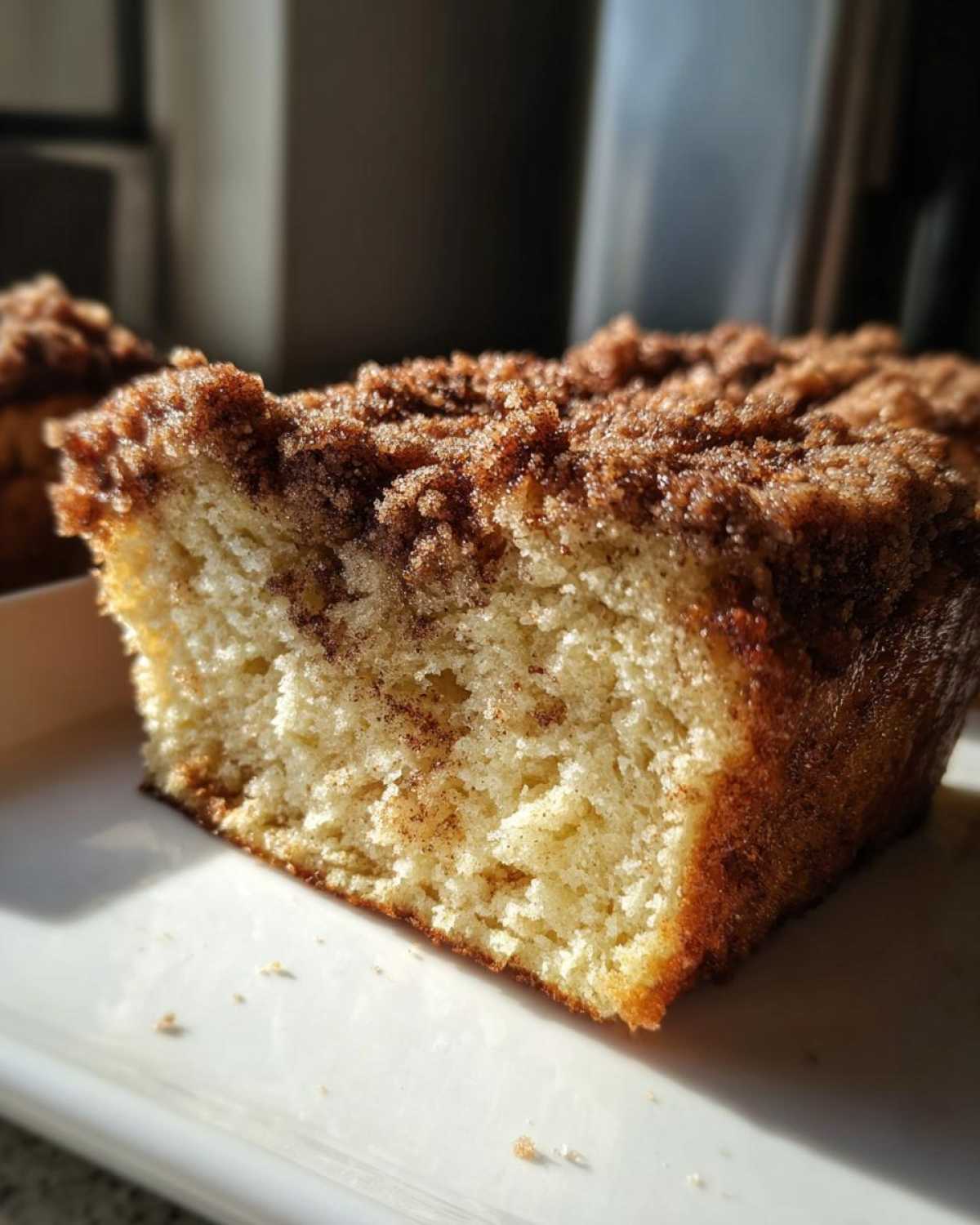 Close-up of a thick slice of Gluten-Free Cinnamon Crunch French Toast showing the soft interior and crunchy cinnamon topping.