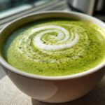 Close-up of a vibrant green beverage, likely a matcha latte, topped with white foam in a spiral design, not the Instant Pot Creamy Asparagus Soup.