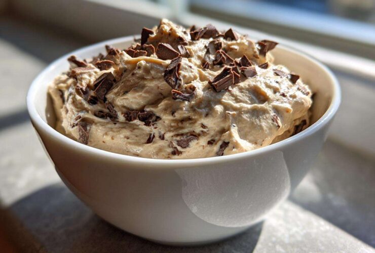 A white bowl filled with creamy Keto Chocolate Chip Cookie Dough Dip topped with chocolate chunks.
