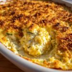 Close-up of a scoop taken from the Cheesy Summer Squash Casserole, showing creamy interior and golden, crunchy topping.