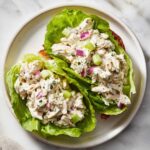 Two servings of Classic Chicken Salad for Sandwiches or Lettuce Wraps served in crisp lettuce cups on a white plate.