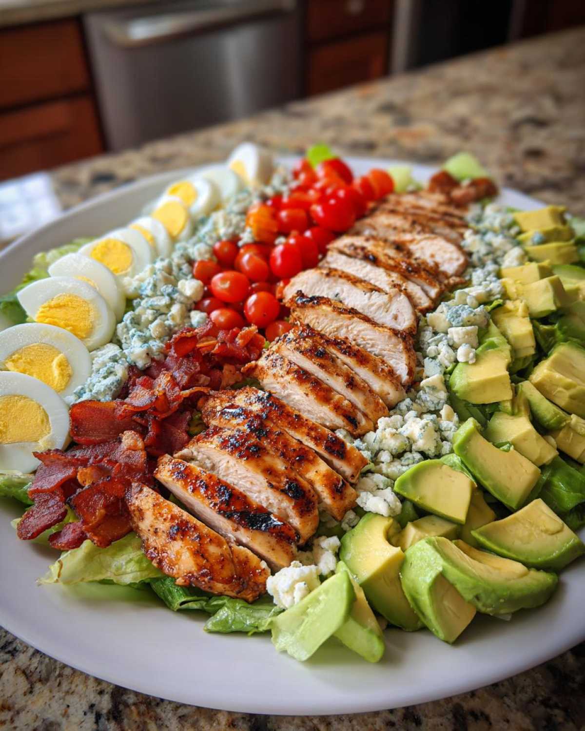A beautifully arranged platter featuring a Classic Cobb Salad with Grilled Chicken, hard-boiled eggs, bacon, avocado, and blue cheese.