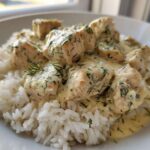 Close-up of tender chicken pieces covered in creamy tzatziki sauce with dill, served over white rice, ready for the Dump-and-Bake Chicken Tzatziki Recipe.