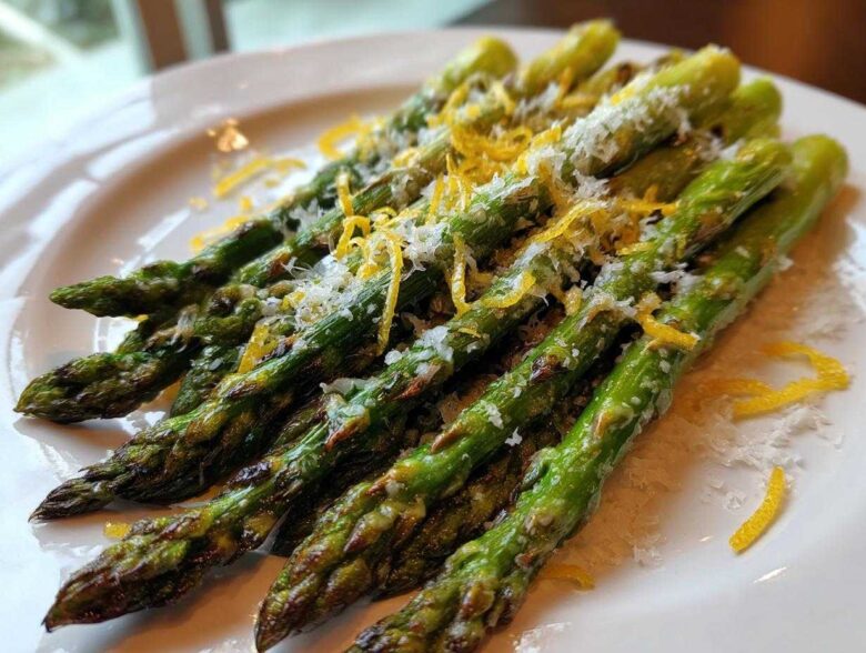 Close-up of perfectly Grilled Asparagus Spears with Parmesan and Lemon zest on a white plate.