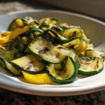 Close-up of Grilled Zucchini and Yellow Squash Ribbons with visible grill marks served in a white bowl.